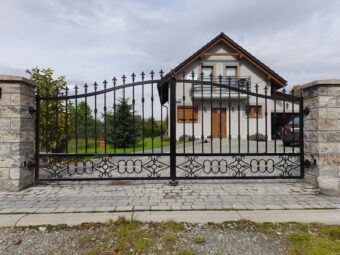 Brama ogrodzeniowa wjazdowa uchylna kuta z&nbsp;podłużnych prętów&nbsp;BU 098