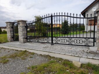 Brama ogrodzeniowa wjazdowa uchylna kuta z&nbsp;podłużnych prętów&nbsp;BU 098
